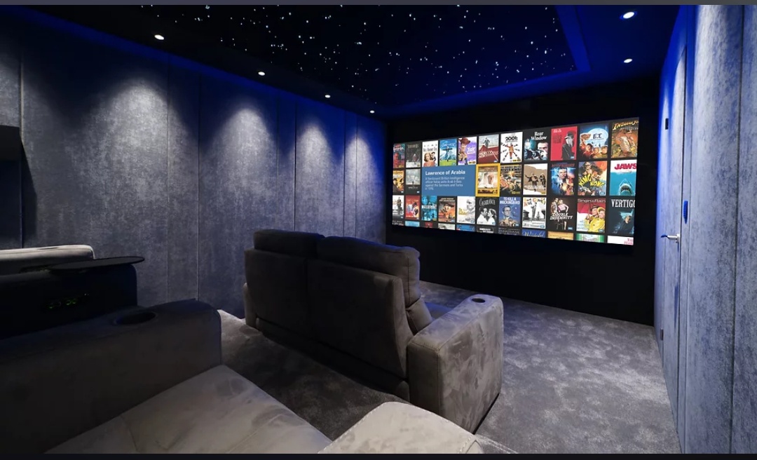 Home theatre setup with large movie library display by YHWH VISION